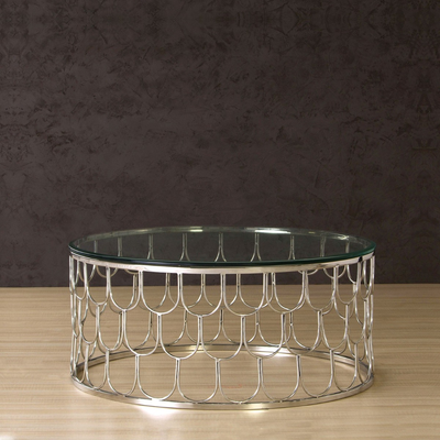 Round coffee table with glass top supported by stainless steel frame in chrome finish
