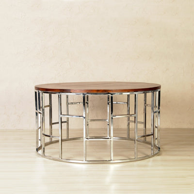 Round coffee table with wooden top supported by stainless steel frame in chrome finish