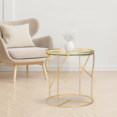 Round side or end table with glass top, supported by metal legs in gold finish