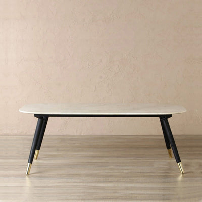 Rectangle coffee table with natural white marble top supported by mango wood legs with brass cones 