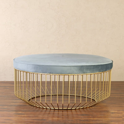 Round coffee table cum ottoman with blue velvet fabric top supported by metal frame in gold finish