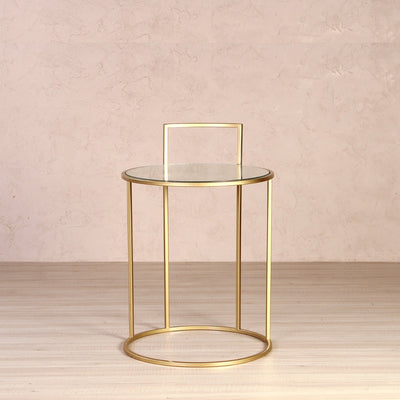 Round side or end table with glass top, supported by metal legs and finished in gold finish